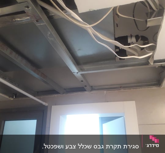 תקרת גבס פתוחה עם חוטי חשמל ומסגרת מתכת